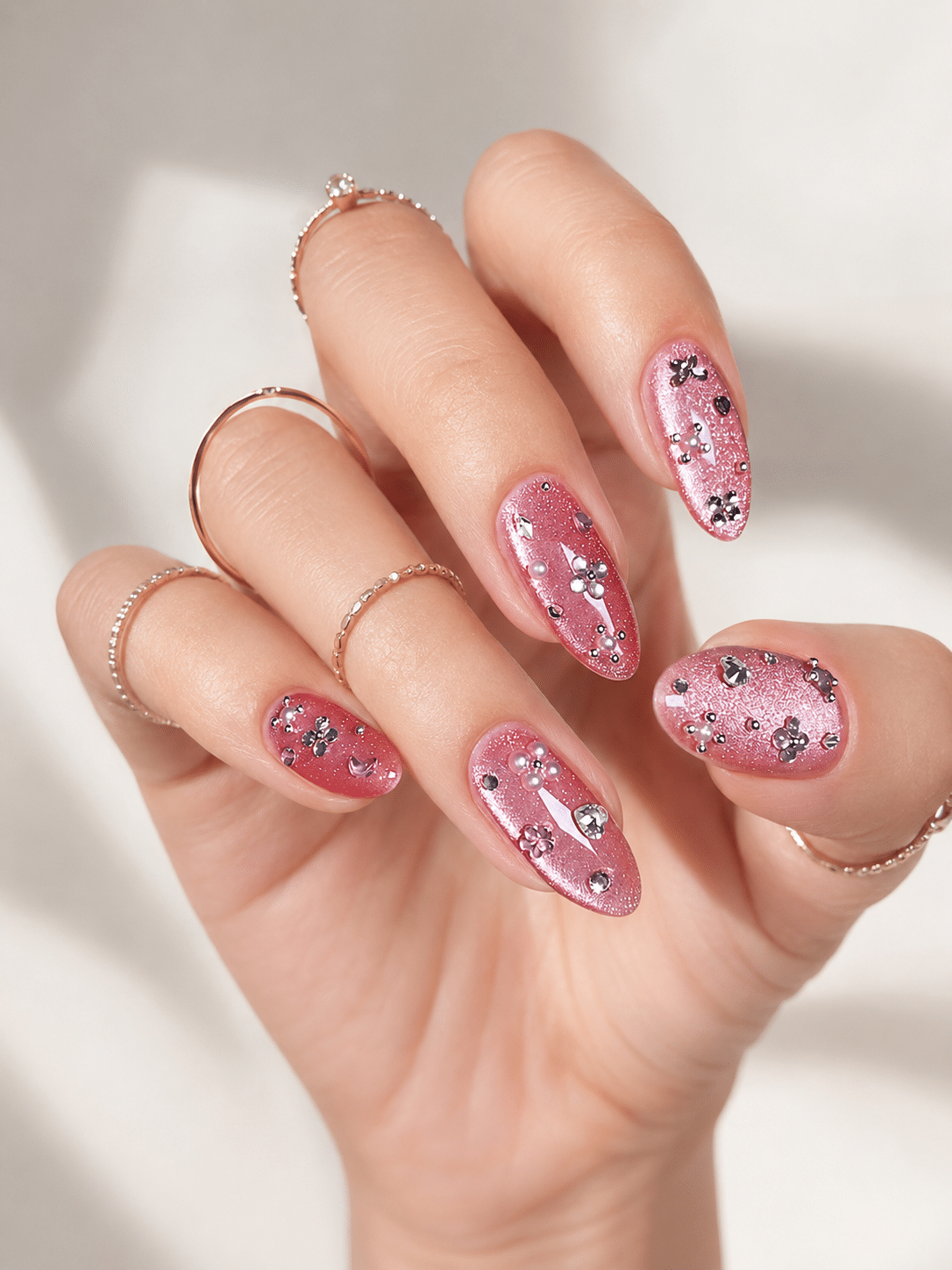 Pink glitter cat eye nail art with floral accent details