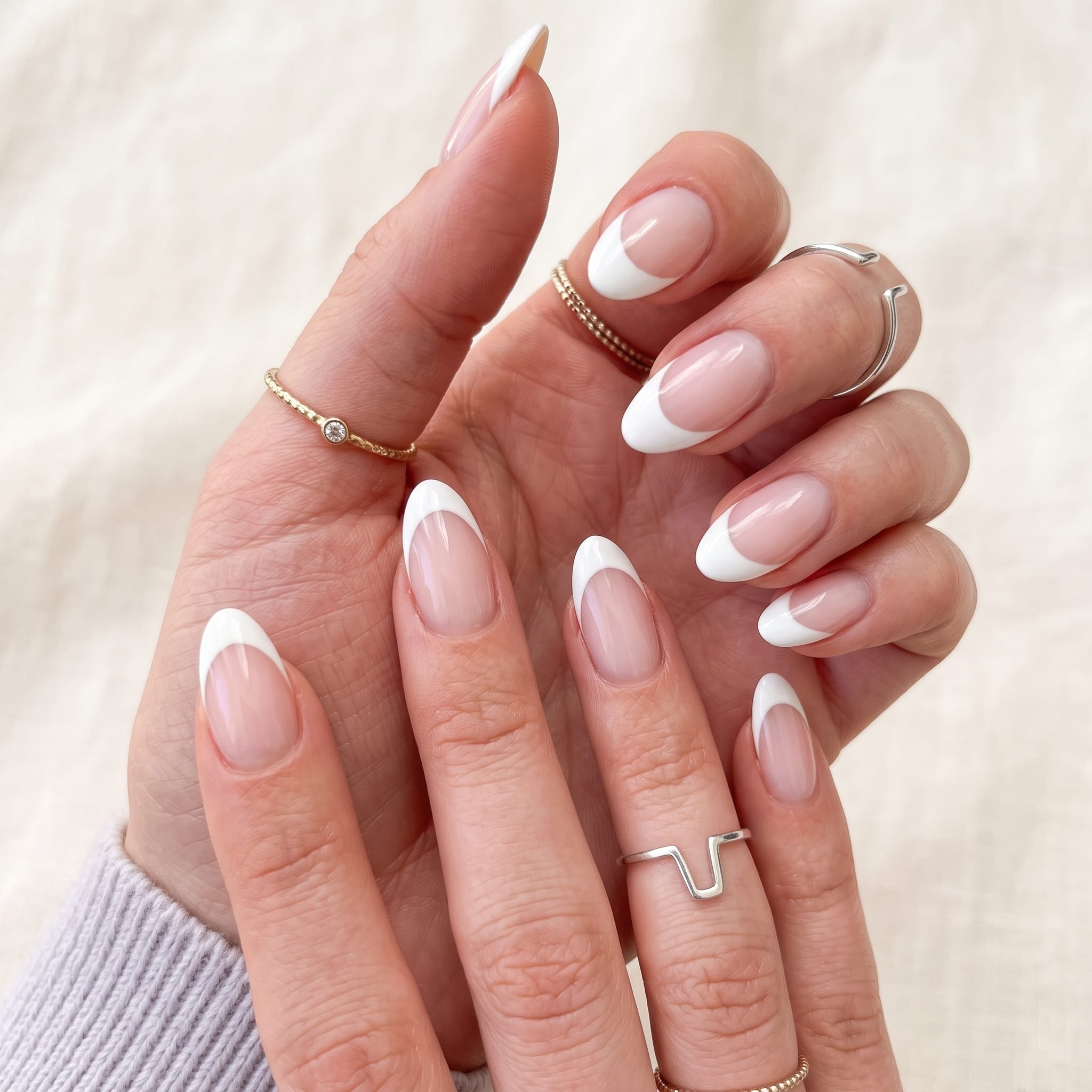 Pink and white full set nails with a soft almond shape and glossy salon finish