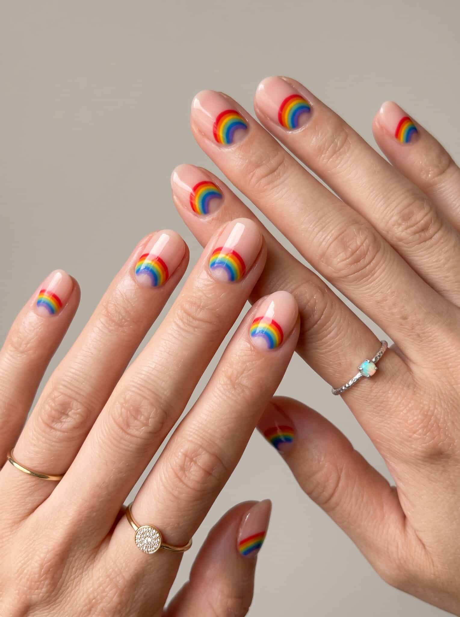 Peach pink nails with slim yellow and orange stripe accents