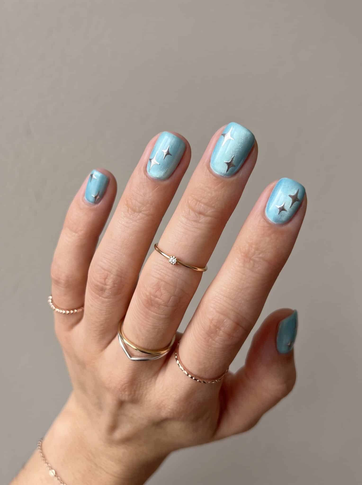 Nude pink manicure with small white heart accent details