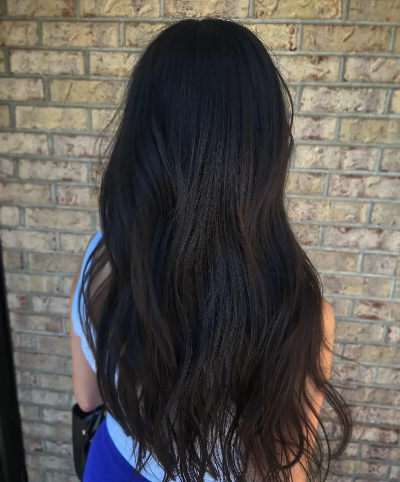 Natural black long tousled waves representing 15 Glossy Dark Hair Color Ideas