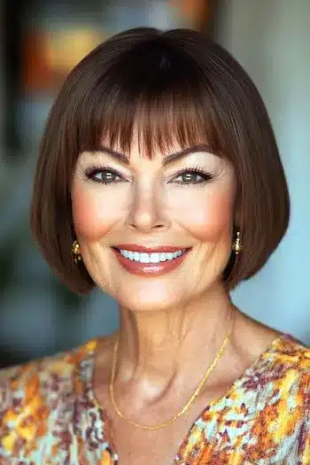 34 Sleek Bob Haircuts With Bangs That Feel Fresh and On-Trend 4 Chin-length rounded bob with piecey bangs on a smiling woman, featured in 34 Sleek Bob Haircuts With Bangs That Are Totally On-Trend.