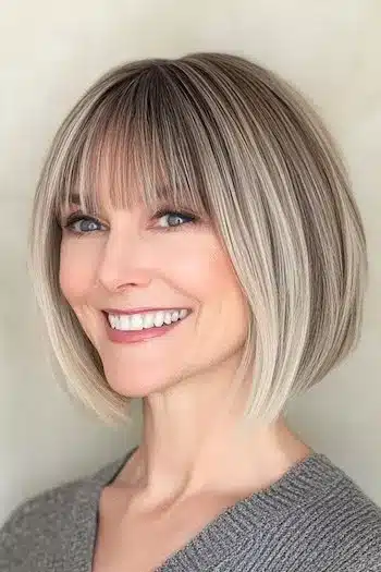 34 Sleek Bob Haircuts With Bangs That Feel Fresh and On-Trend 35 Wispy Bob With Bangs for Fine Hair Haircut on a smiling woman with brownish blonde hair.